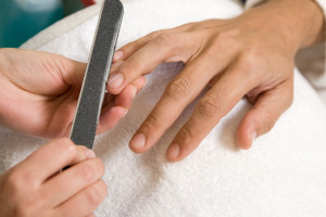 a man is getting manicure in salon